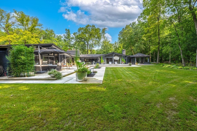 view of yard featuring a patio area and glass enclosure