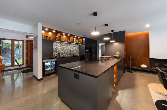 kitchen with sink, a center island, wine cooler, tasteful backsplash, and decorative light fixtures