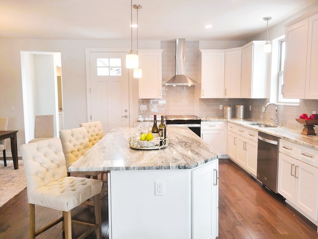 kitchen featuring a kitchen island, wall chimney range hood, and appliances with stainless steel finishes