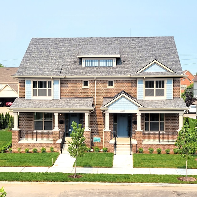 craftsman-style house featuring covered porch and a front lawn