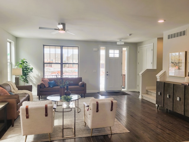 living room with ceiling fan and dark wood-type flooring