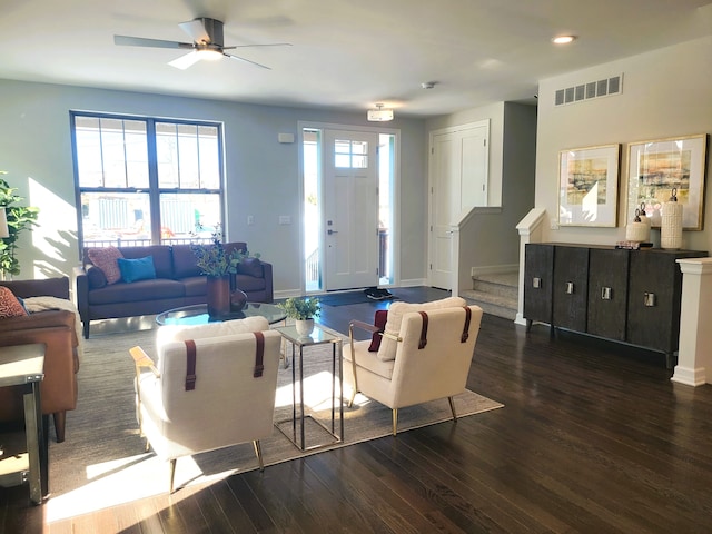 living room with ceiling fan and dark hardwood / wood-style flooring