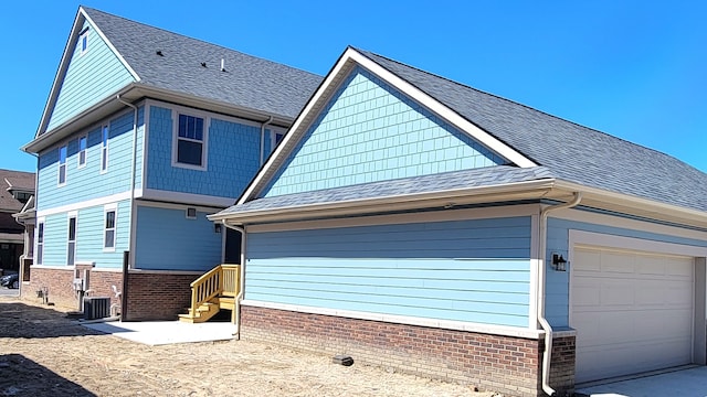 exterior space featuring a garage and central AC