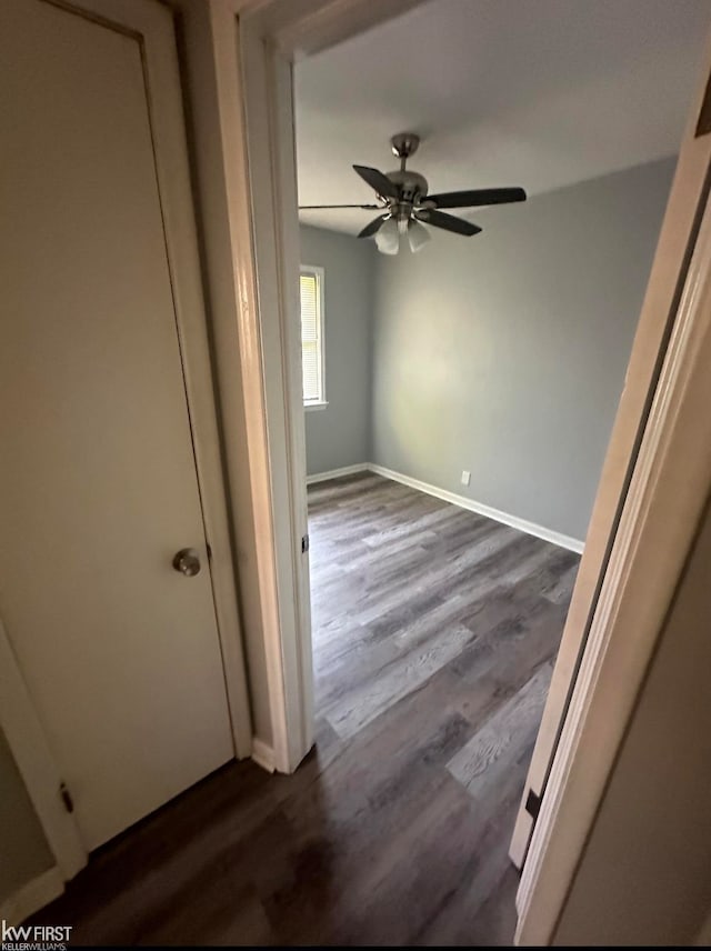 spare room with dark hardwood / wood-style flooring and ceiling fan