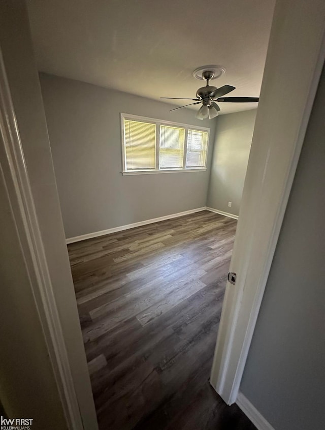 spare room with dark hardwood / wood-style floors and ceiling fan