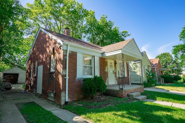 view of front of home featuring a front yard, a garage, and an outdoor structure