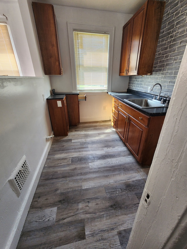 kitchen featuring tasteful backsplash, hardwood / wood-style floors, and sink