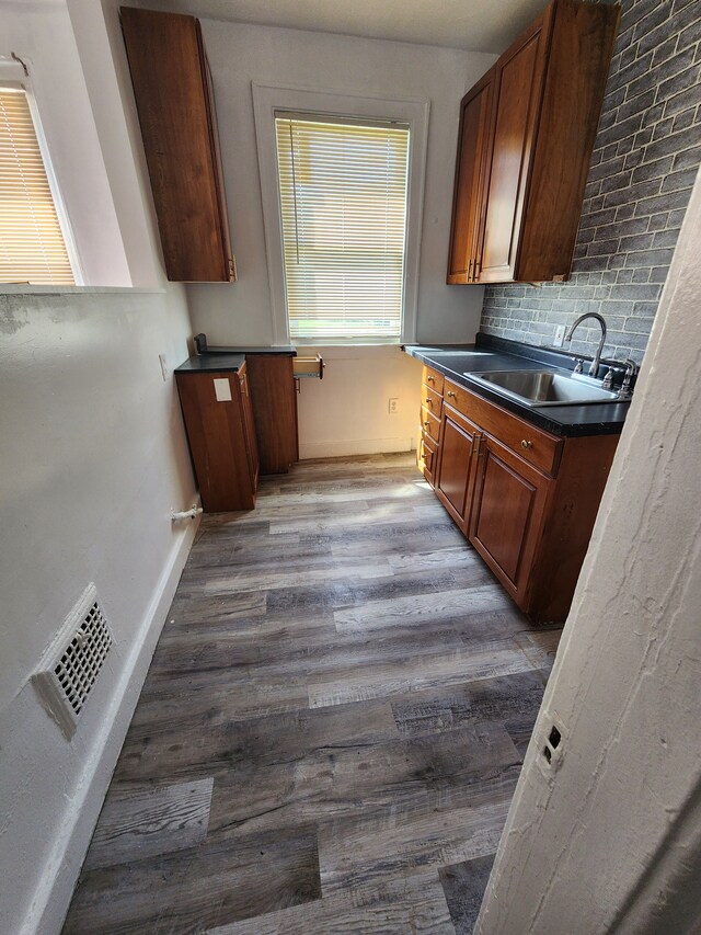 9369 Genessee, Detroit, MI 48206 - kitchen with a sink, dark countertops, wood finished floors, baseboards, and backsplash
