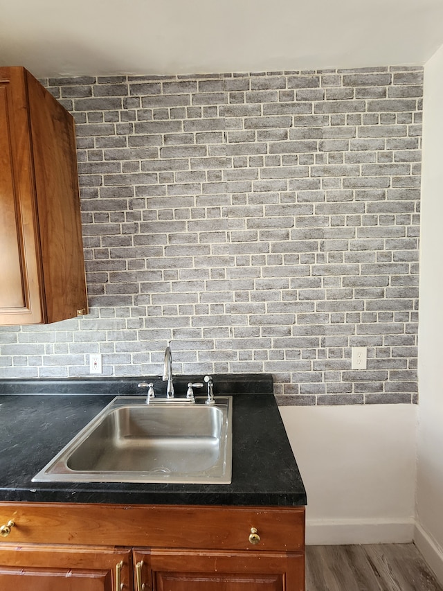 kitchen with tasteful backsplash, hardwood / wood-style floors, and sink