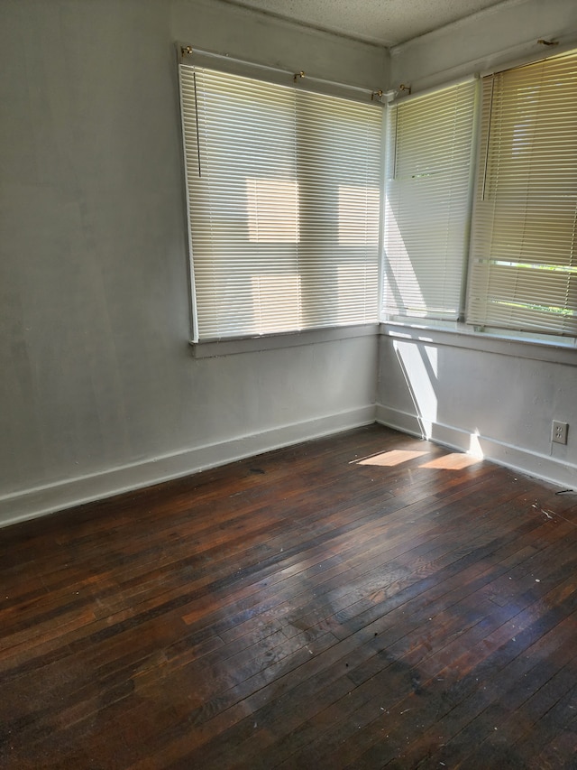 unfurnished room with dark hardwood / wood-style flooring