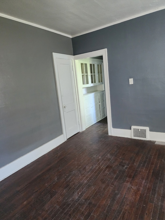 spare room featuring dark hardwood / wood-style flooring and ornamental molding