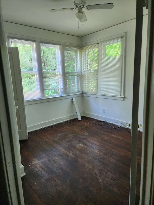 unfurnished sunroom featuring ceiling fan