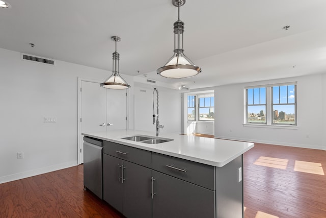 kitchen featuring sink, decorative light fixtures, dark hardwood / wood-style floors, dishwasher, and a kitchen island with sink