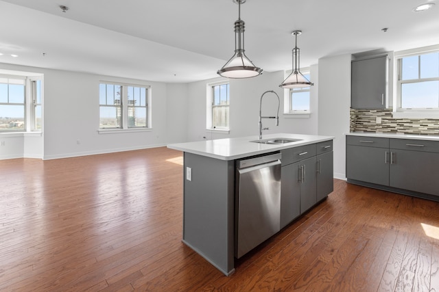 kitchen with sink, dishwasher, a kitchen island with sink, hanging light fixtures, and gray cabinetry