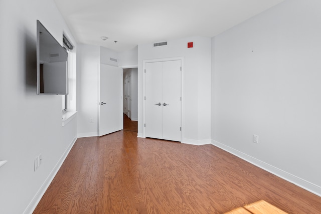 unfurnished bedroom featuring hardwood / wood-style floors and a closet