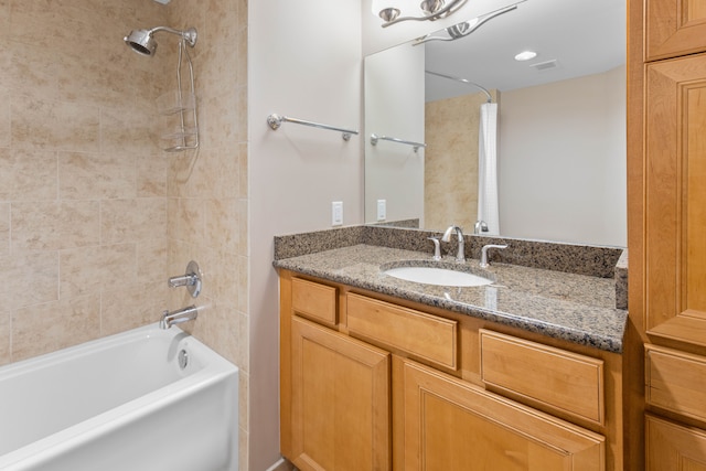 bathroom with vanity and tiled shower / bath combo