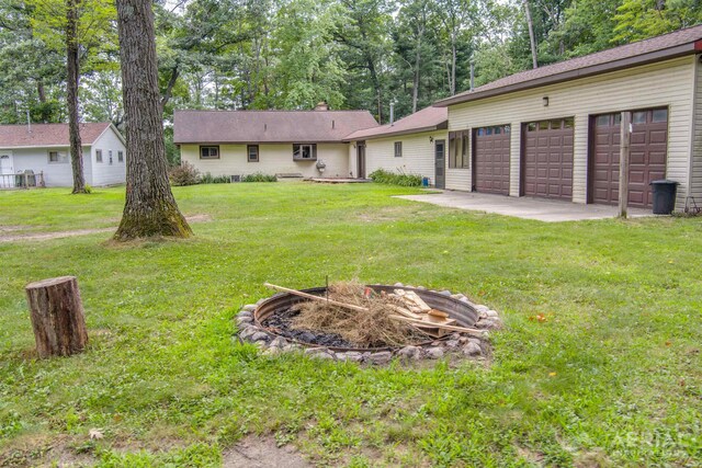 4100 Grass Lake Rd, West Branch, MI 48661 - view of green lawn with a garage, driveway, and view of scattered trees