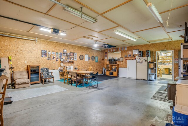 4100 Grass Lake Rd, West Branch, MI 48661 - garage featuring freestanding refrigerator and a garage door opener