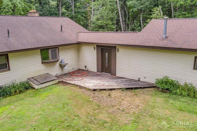 4100 Grass Lake Rd, West Branch, MI 48661 - back of house with a shingled roof, a chimney, a yard, and a deck