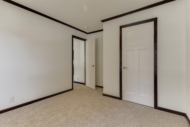 unfurnished bedroom featuring crown molding and light carpet