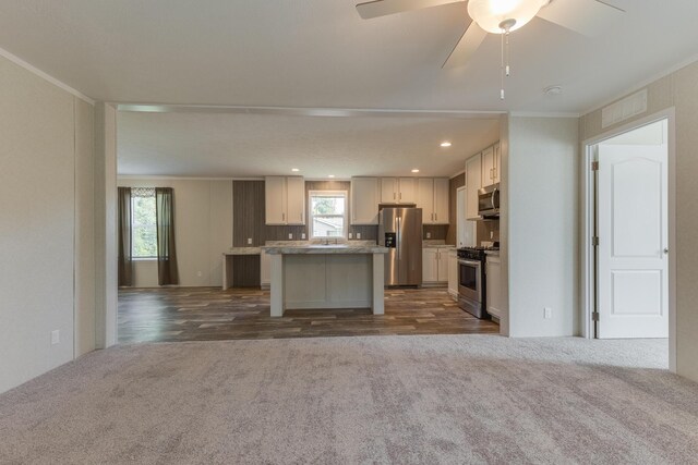 575 Gallery Dr Unit 48, Eaton Rapids, MI 48827 - kitchen with stainless steel appliances, plenty of natural light, dark carpet, a center island, and ornamental molding