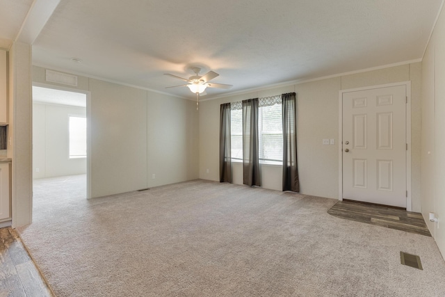 575 Gallery Dr Unit 48, Eaton Rapids, MI 48827 - unfurnished living room featuring a ceiling fan, ornamental molding, and light colored carpet