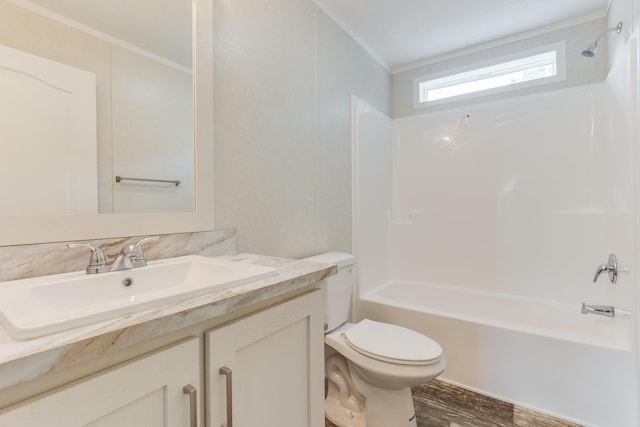 575 Gallery Dr Unit 48, Eaton Rapids, MI 48827 - bathroom featuring crown molding, toilet, vanity, washtub / shower combination, and wood finished floors