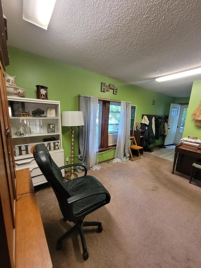 carpeted home office with a textured ceiling