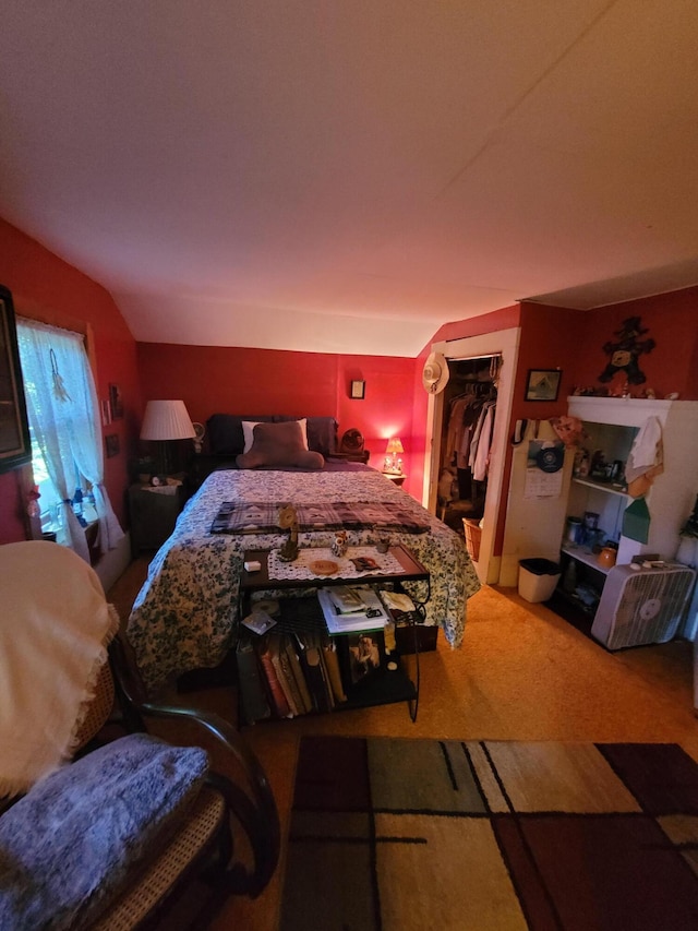 carpeted bedroom with a walk in closet, lofted ceiling, and a closet