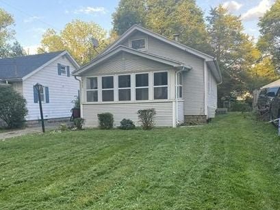 rear view of house featuring a lawn