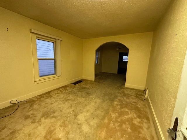 unfurnished room featuring carpet and a textured ceiling