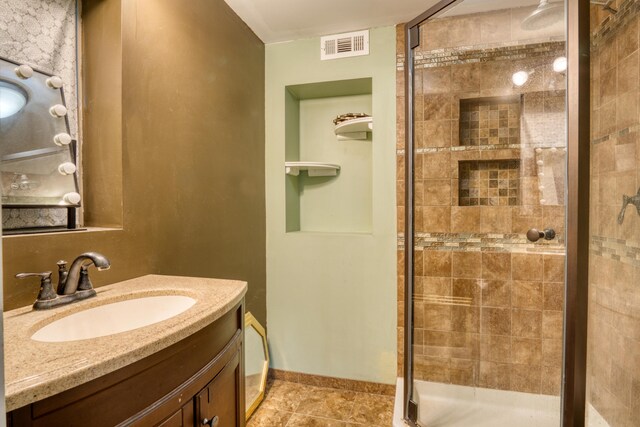 bathroom with tile patterned flooring, vanity, and walk in shower