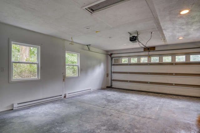 garage featuring a garage door opener and a baseboard heating unit