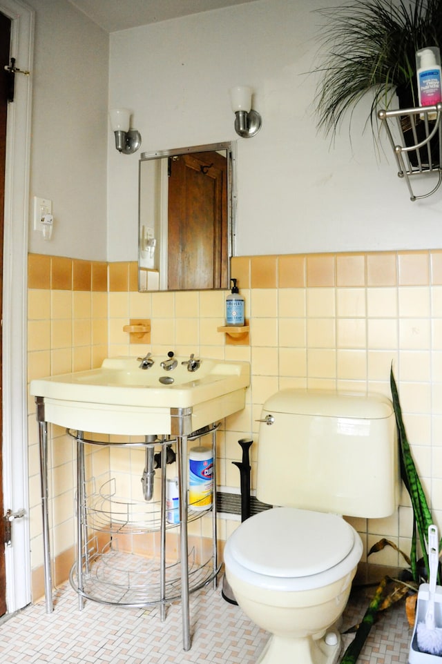 bathroom with toilet and tile walls