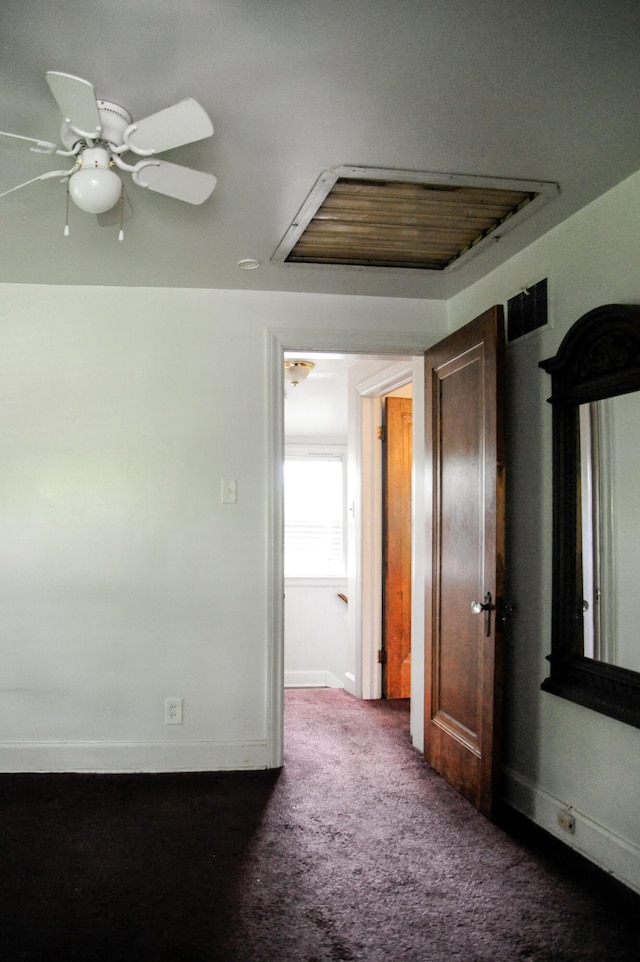 empty room with ceiling fan and dark carpet