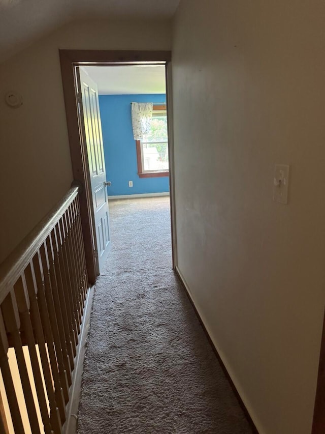 hall with carpet flooring and vaulted ceiling