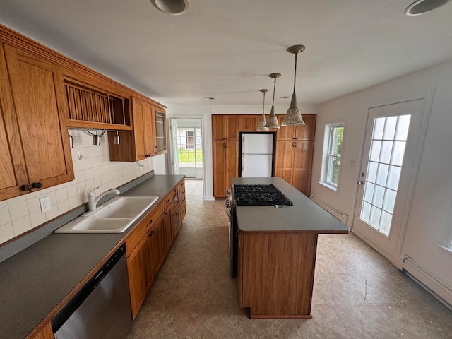 kitchen featuring sink, white refrigerator, dishwasher, a kitchen island, and hanging light fixtures