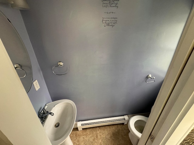 bathroom featuring baseboard heating, toilet, sink, and tile patterned flooring