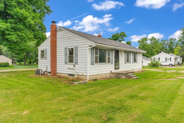 back of house featuring a lawn and central AC