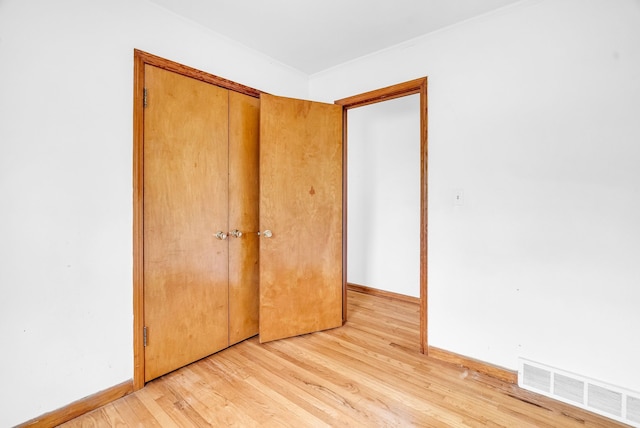 unfurnished bedroom with light hardwood / wood-style flooring and a closet