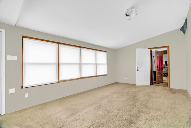 carpeted spare room featuring lofted ceiling