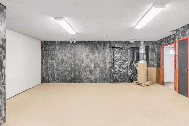 basement featuring carpet flooring and a textured ceiling