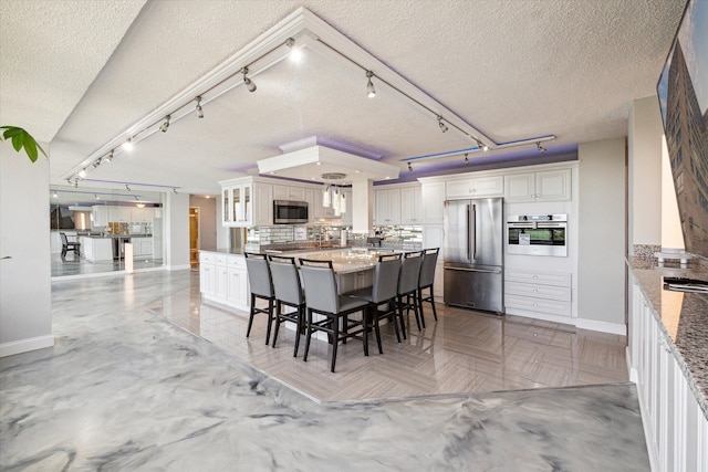 dining room with rail lighting and a textured ceiling