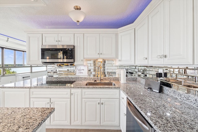 kitchen featuring a textured ceiling, sink, white cabinetry, and stainless steel appliances