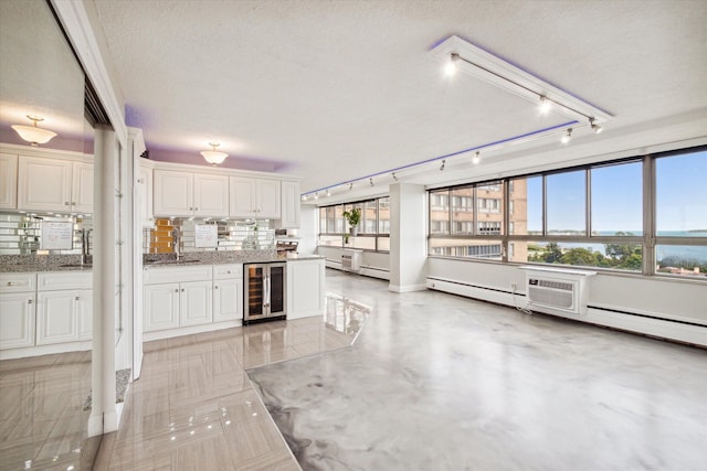 kitchen featuring white cabinets, decorative backsplash, a textured ceiling, and wine cooler