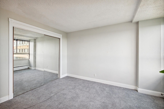 unfurnished bedroom with carpet flooring, a closet, a textured ceiling, and a baseboard radiator