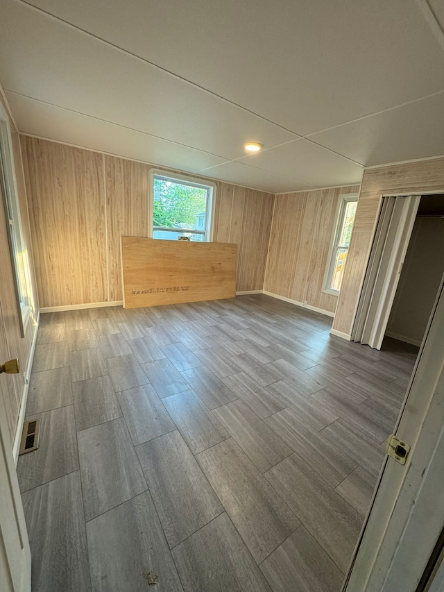 empty room featuring wood walls and wood-type flooring