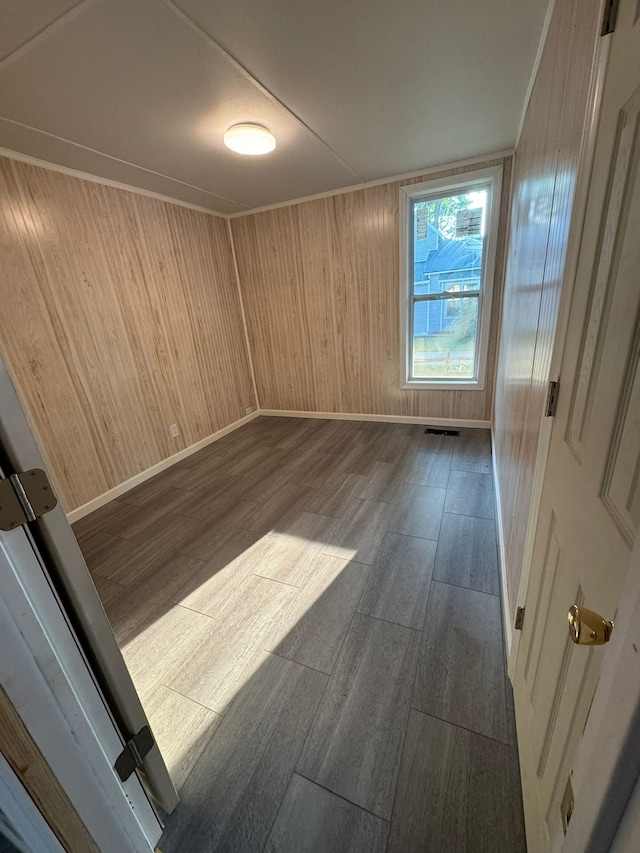 unfurnished room featuring dark hardwood / wood-style flooring and wooden walls