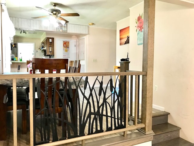 bar with wood-type flooring and ceiling fan