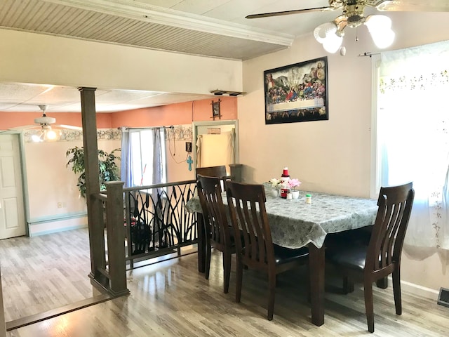 dining room with ornate columns, ceiling fan, and light hardwood / wood-style floors